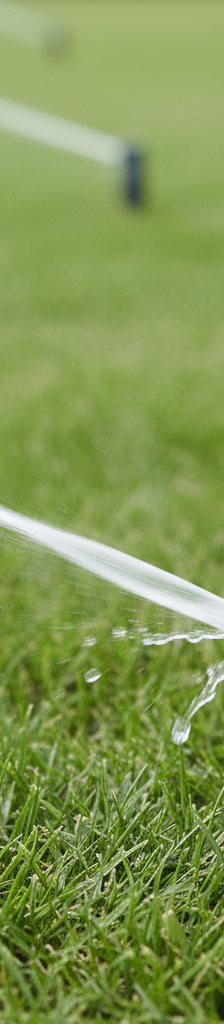 Hand adjusting a pop-up rotor sprinkler head with a screwdriver to modify spray pattern