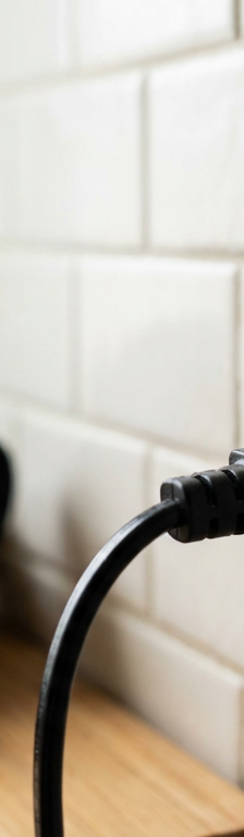 A hair dryer plugged into a bathroom GFCI outlet with the red reset button tripped.