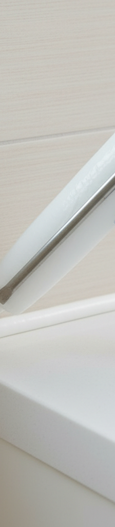 Skilled hand applying a perfect caulk bead between tile and a countertop, emphasizing proper technique and a smooth finish.