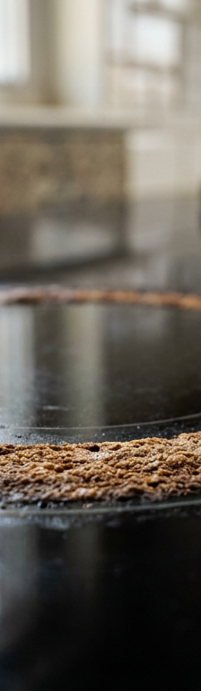 Burnt ring of grease and food residue on a black ceramic glass cooktop