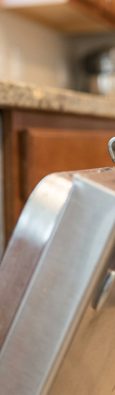 Close-up of a dishwasher door latch and strike plate, showing the mechanism that locks the door.