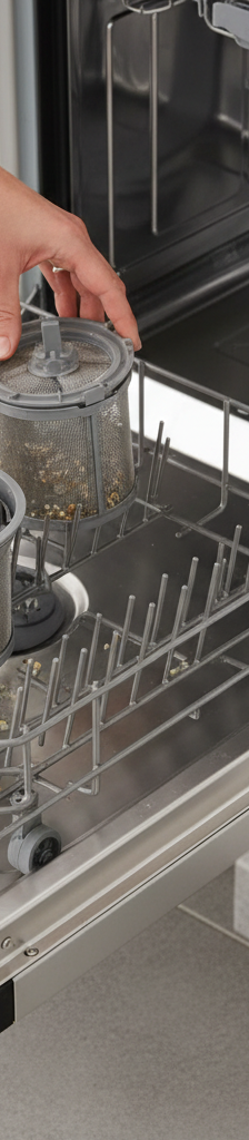 Homeowner inspecting and cleaning a dishwasher filter to fix a draining problem