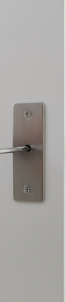 Homeowner adjusting a door strike plate with a screwdriver to fix a non-latching door.