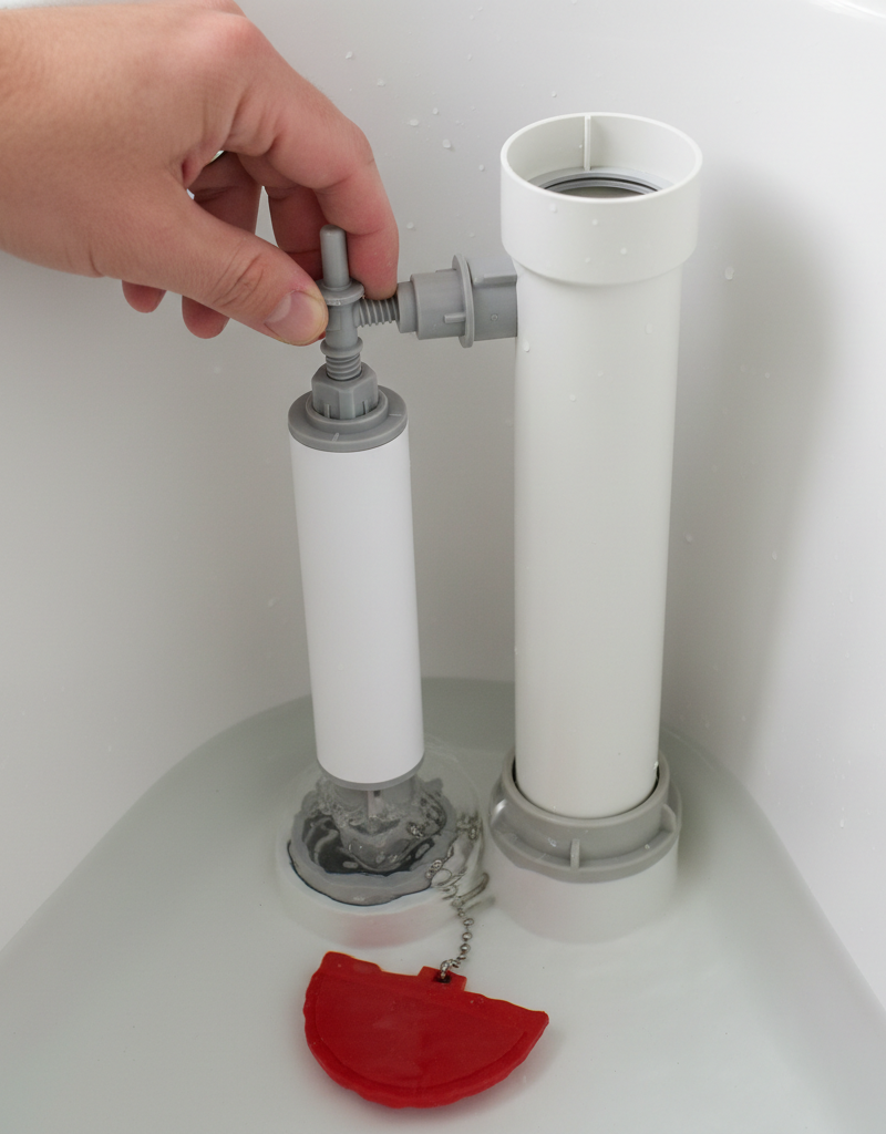 Homeowner adjusting fill valve and float in a toilet tank to stop a running toilet.