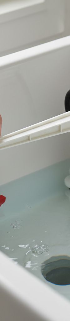 Homeowner adjusting a toilet's float arm inside the tank to stop continuous running