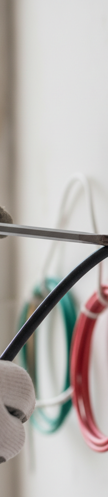 Contractor's hands disconnecting wires from a faulty light switch, showing safe electrical repair.