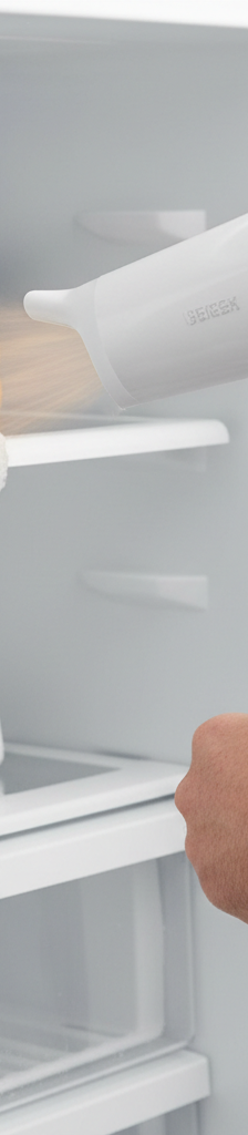 Homeowner defrosting a refrigerator ice maker fill tube with a hairdryer.