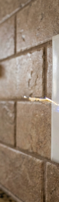 A faulty kitchen light switch for a garbage disposal is sparking with electricity.