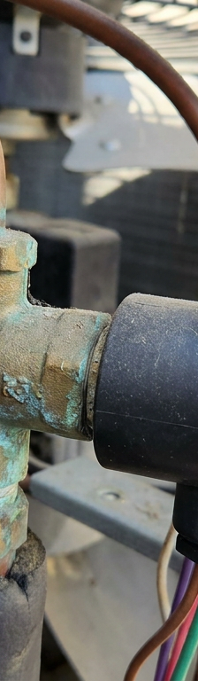 A close-up of a heat pump reversing valve, the part that switches the unit from heat to AC.