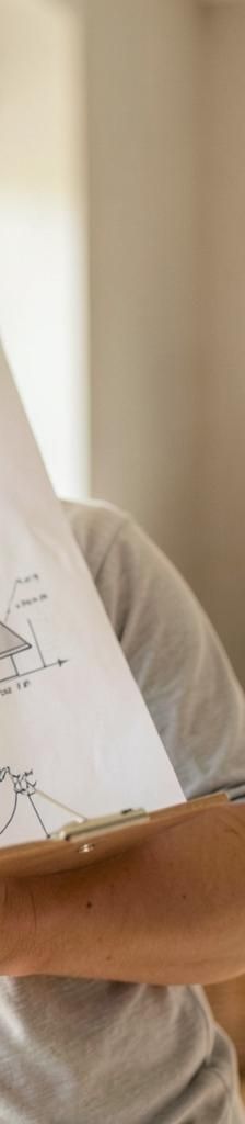 Homeowner reviewing repair and replacement plans for HVAC, roof, and water heater systems in a bright modern home