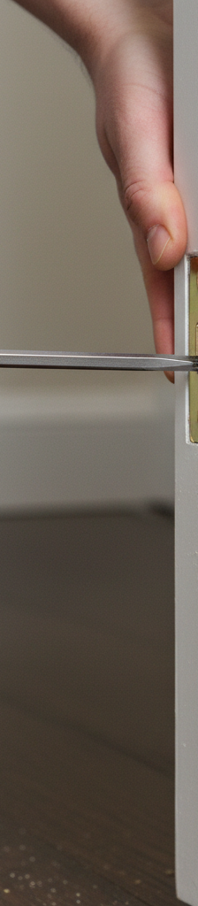 Homeowner tightening a hinge screw on a wooden interior door to fix sticking.