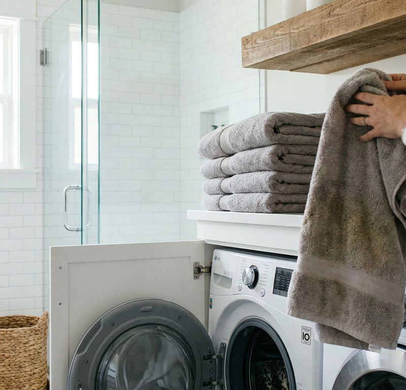 A stack of clean but musty-smelling bath towels in a bathroom.