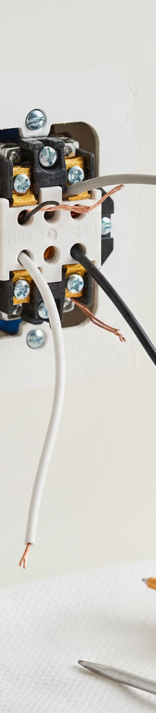 Loose back-tapped wires on the back of an electrical outlet pulled from a wall box.