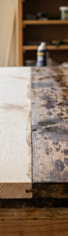 A pine board showing the difference between a clean side and a side with splotchy, uneven stain blotching.
