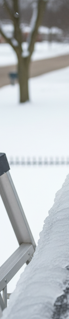 Homeowner safely placing a calcium chloride sock on an ice dam to melt it.