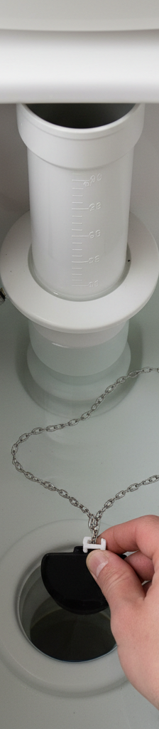 A person's hand adjusting the flapper chain inside a toilet tank to fix a running toilet.