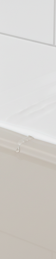 Shower pan joint with clean caulk, showing subtle water seepage, indicating a hidden leak.