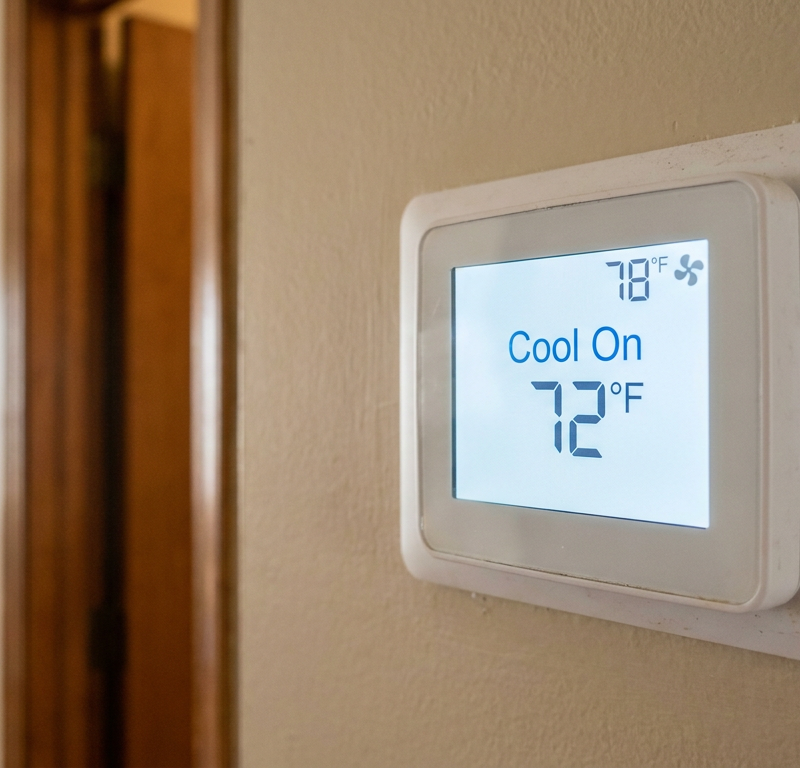 A digital thermostat on a wall shows "Cool On" but the room temperature is much higher than the set temperature.