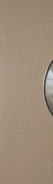 A smart thermostat on a wall showing a Wi-Fi connection error symbol on its screen.