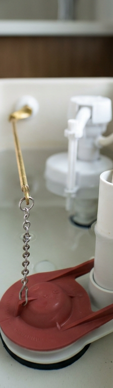 The internal components of a toilet tank, showing the flapper and fill valve responsible for ghost flushing.