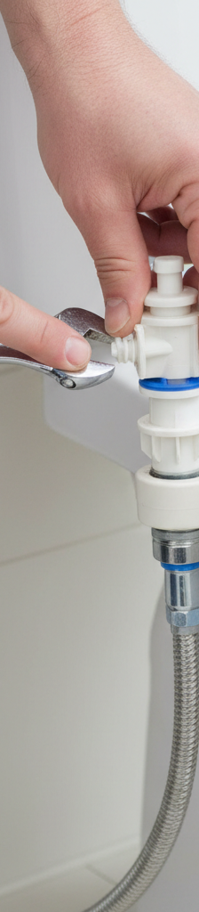 Homeowner inspecting a toilet fill valve and water supply line for slow tank filling