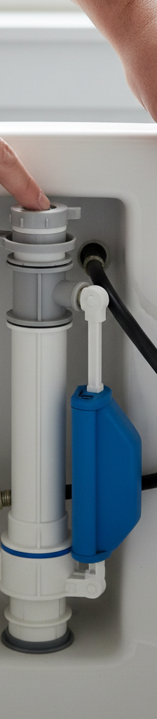 Homeowner inspecting the fill valve inside a toilet tank to troubleshoot slow filling issues.