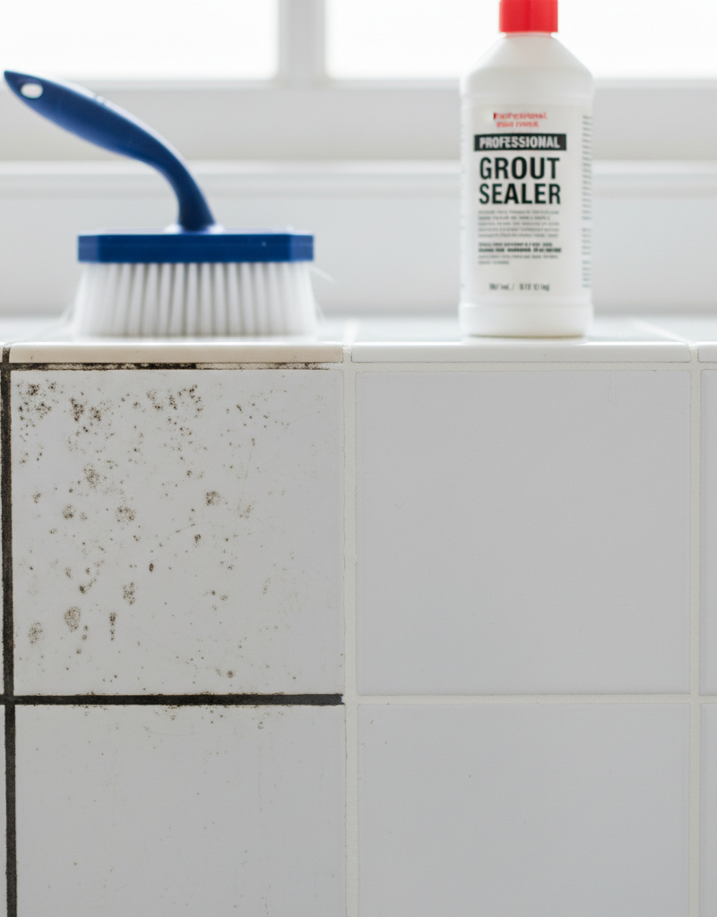 Close-up of dirty bathroom grout next to clean, sealed grout