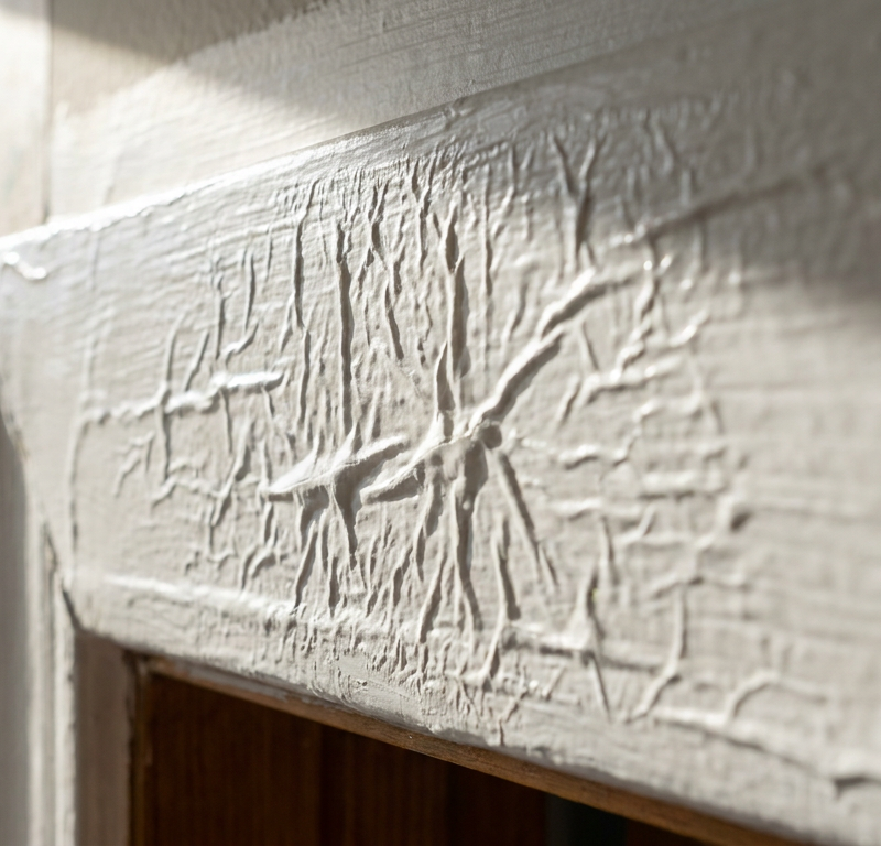 Close-up of wrinkled and puckered fresh paint on an interior wall trim board