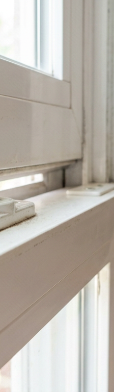 A misaligned white vinyl window lock that will not engage and lock properly.