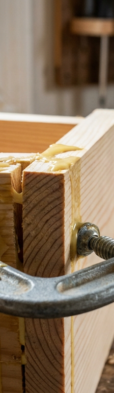 A close-up of a wood joint with wet, tacky wood glue that is not drying properly.